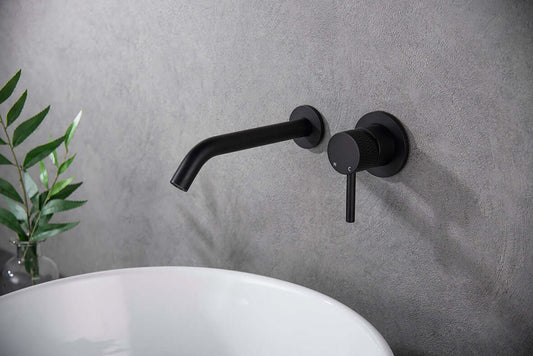 Ribbd Inbouwwastafelkraan Wiesbaden met ééngreeps en afdekplaat in matzwart boven een wastafel.