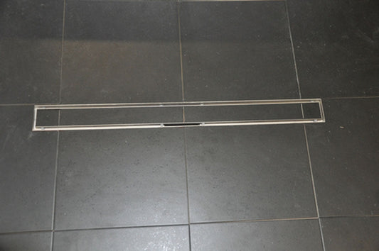 RVS Tegelrooster voor Wiesbaden Douchegoot 50X7 Cm geplaatst op een donkere tegelvloer.