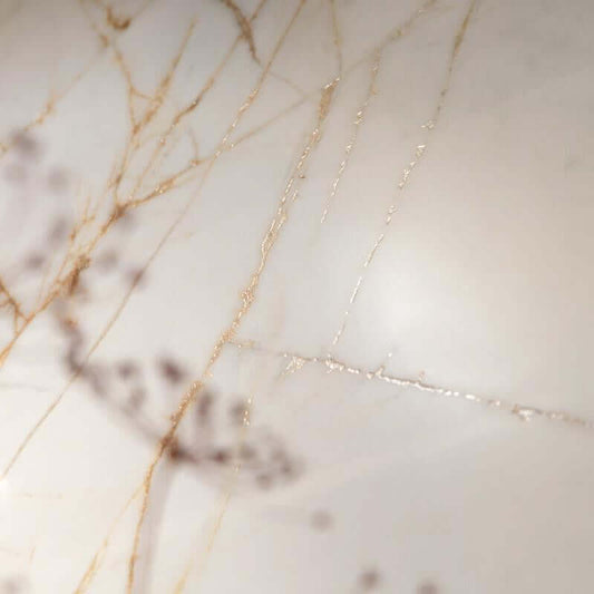 Tegel with subtle gold veins on a light background, showcasing intricate natural patterns in a stylish marble design.