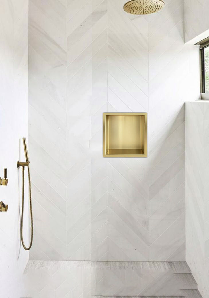inbouwnis in brushed gold finish integrated into a modern shower wall design.